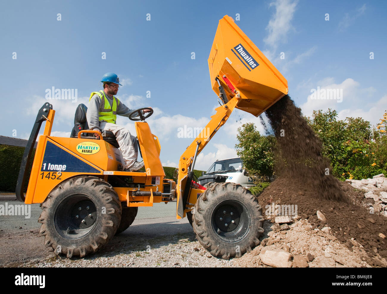 A builder driving a mini dumper truck on a house extension, building job, Ambleside, Cumbria, UK. Stock Photo