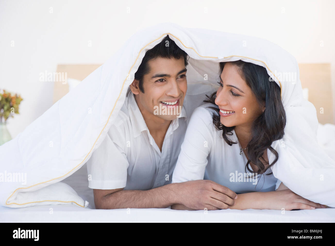 Couple lying on the bed and smiling Stock Photo - Alamy