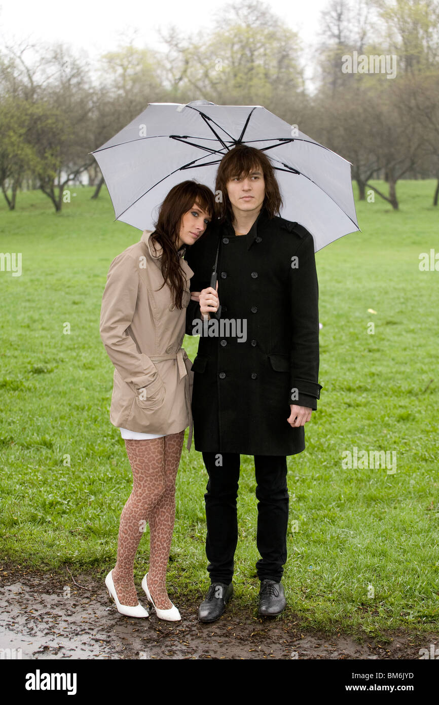 young couple under umbrella in the park Stock Photo - Alamy