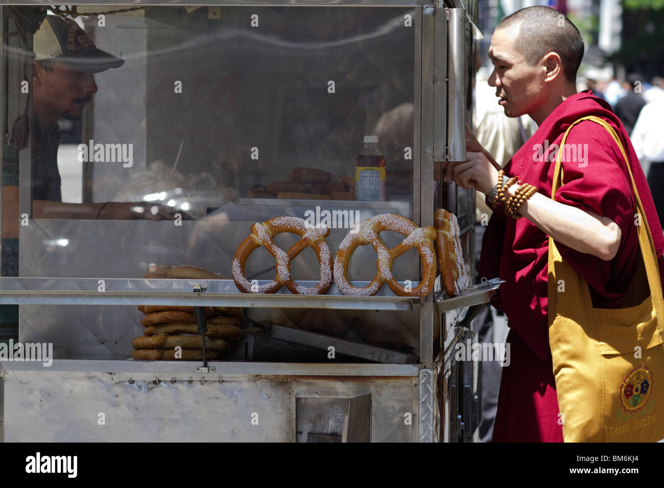 Buddhist Monk at New York's pretzel cart Stock Photo