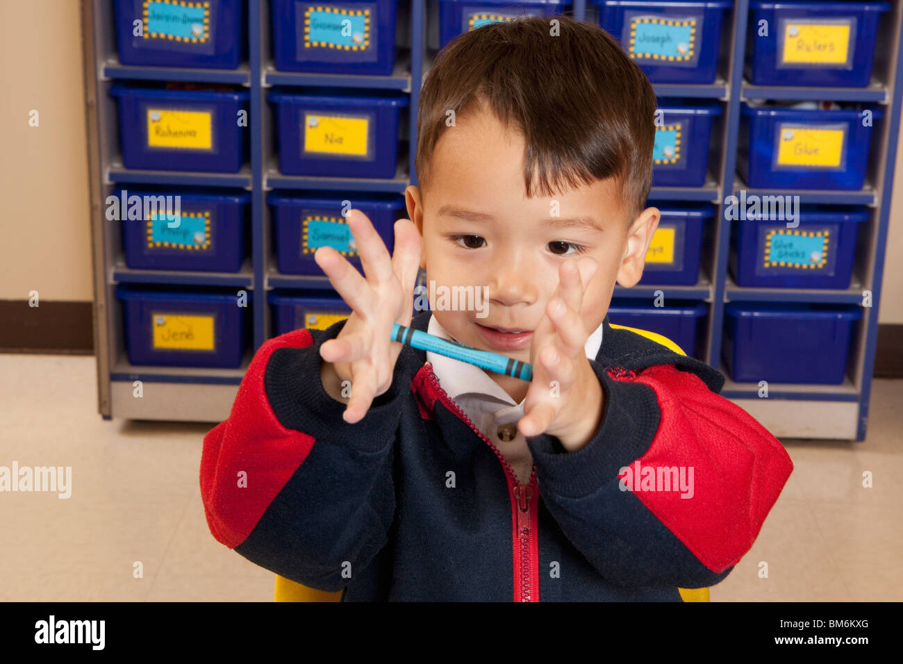 Young Boy Holding A Crayon In His Hands Stock Photo