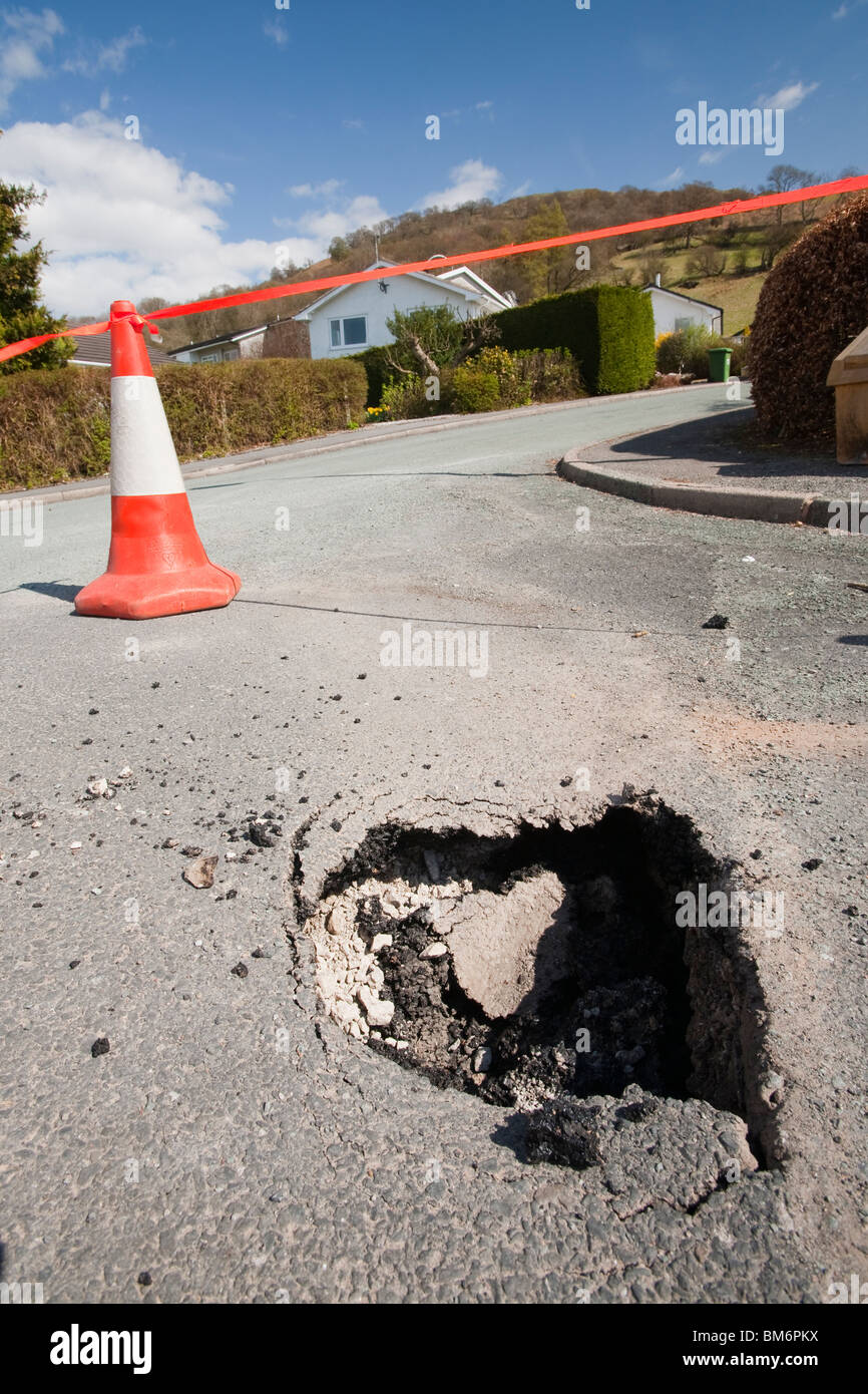 A hole opening up in the road in Ambleside, due to being undermined by flood waters. Stock Photo