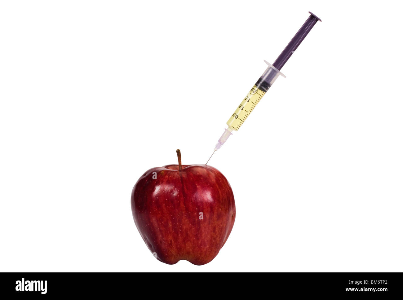Syringe being injected into an apple Stock Photo