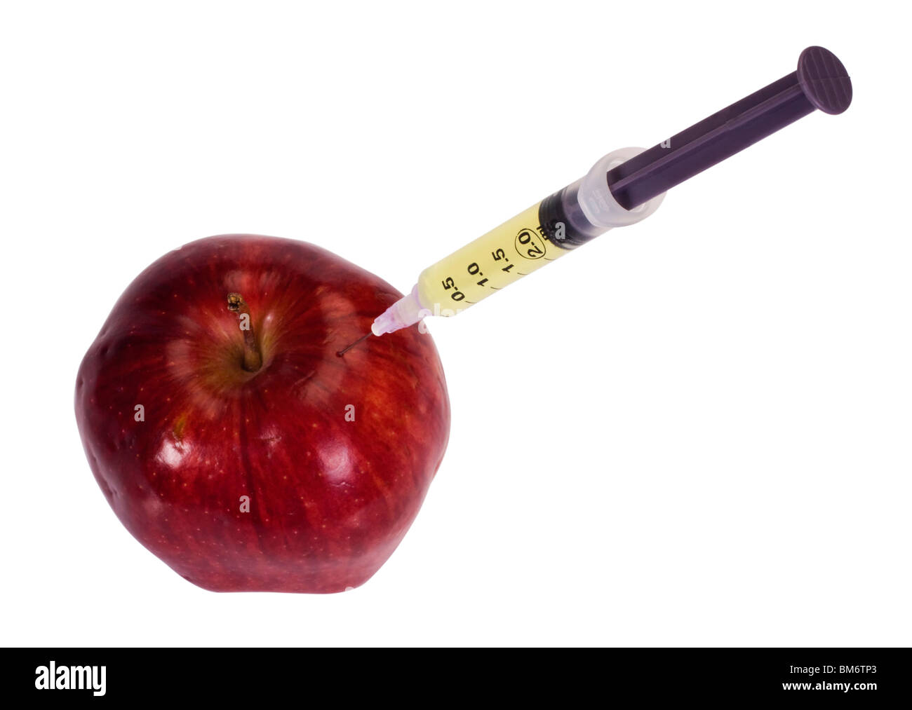 Syringe being injected into an apple Stock Photo