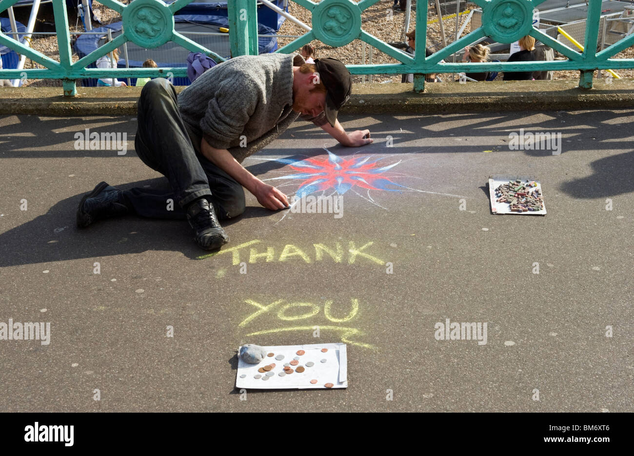 A pavement street artist using coloured chalks to create a chalk