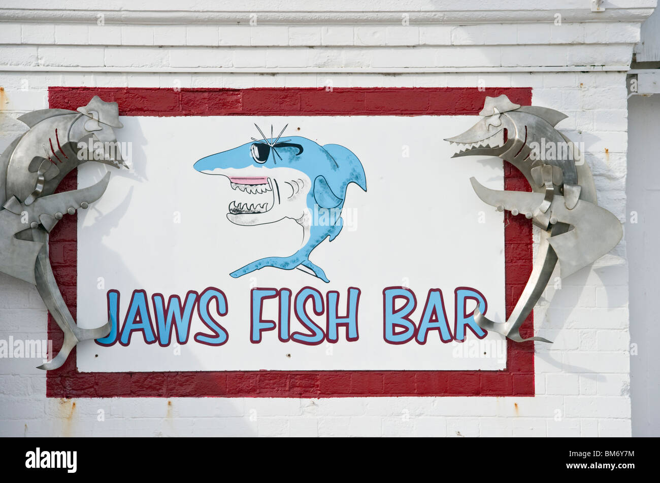 A fish bar sign depicting a shark cartoon character on Brighton front Sussex UK Stock Photo