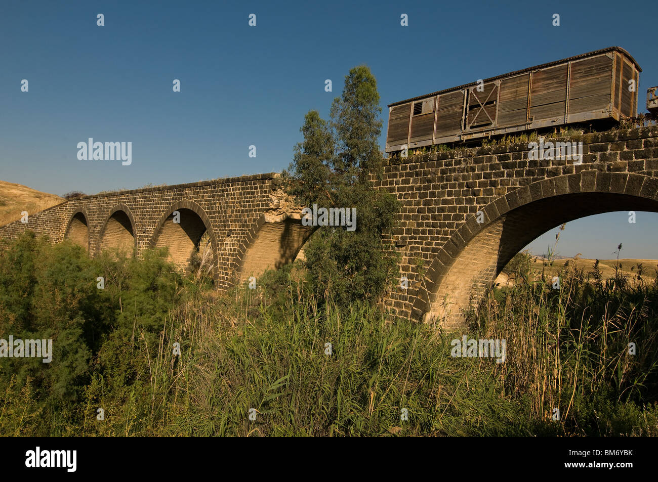 An abandoned train wagon on the former Ottoman railroad bridge at the old Gesher Railway Station of the Jezreel Valley Railway in Gesher, Israel Stock Photo