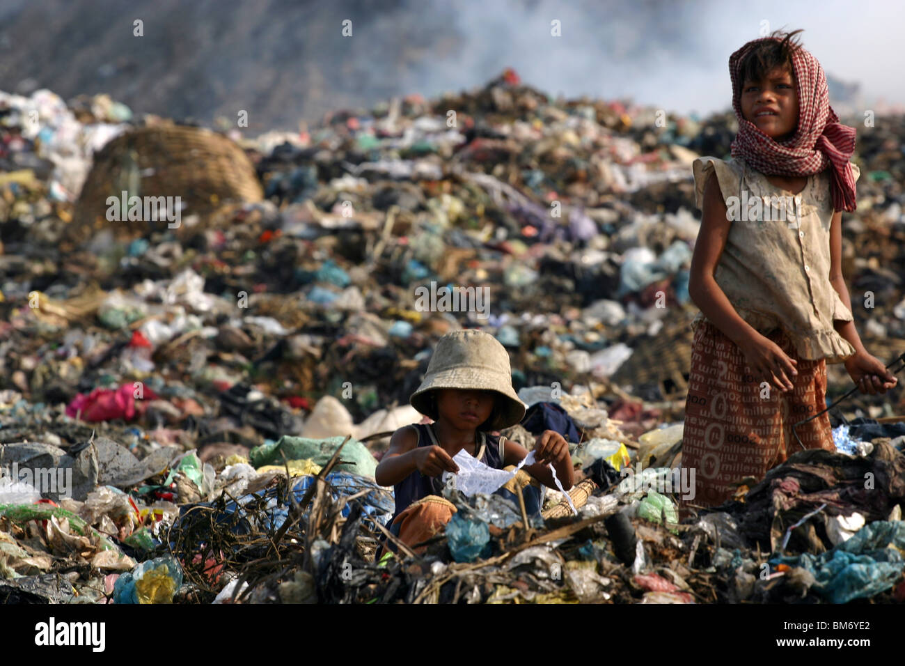 Two young girls scavenging for recyclables the garbage dump in Phnom Penh, Cambodia. Stock Photo
