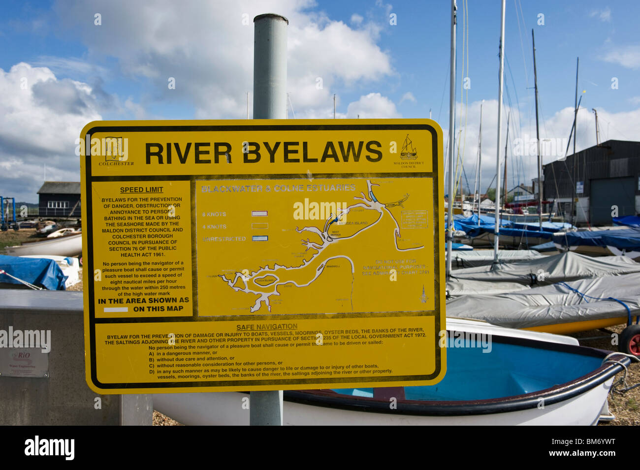 A yellow notice depicting local river bylaws on Mersea island Essex UK Stock Photo