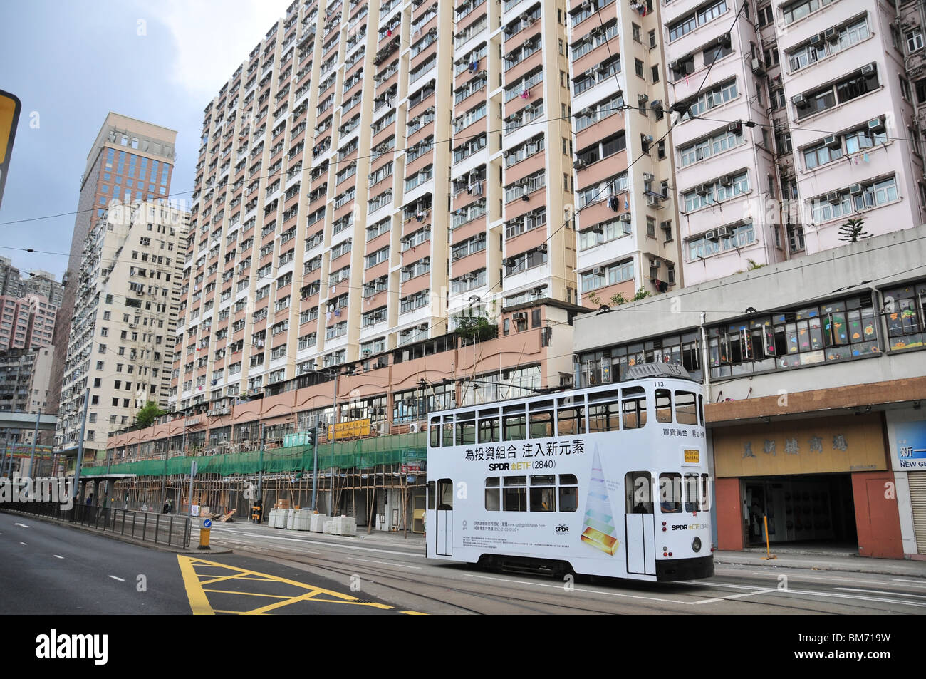 Tram, travelling along Des Voeux Road West, past apartments with bamboo