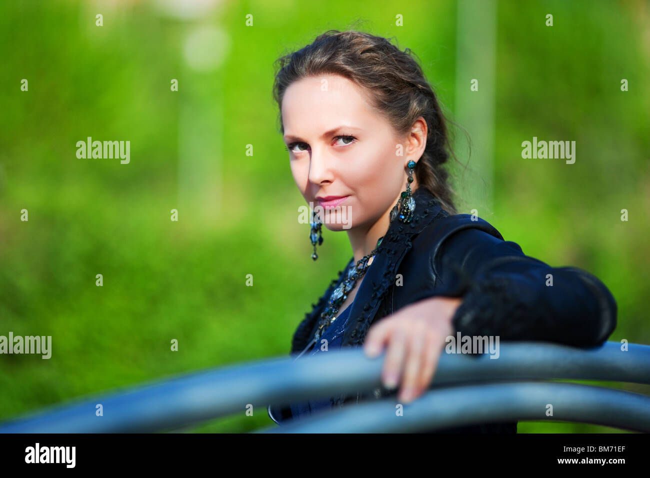 Young woman sitting on a bench in the city park Stock Photo - Alamy