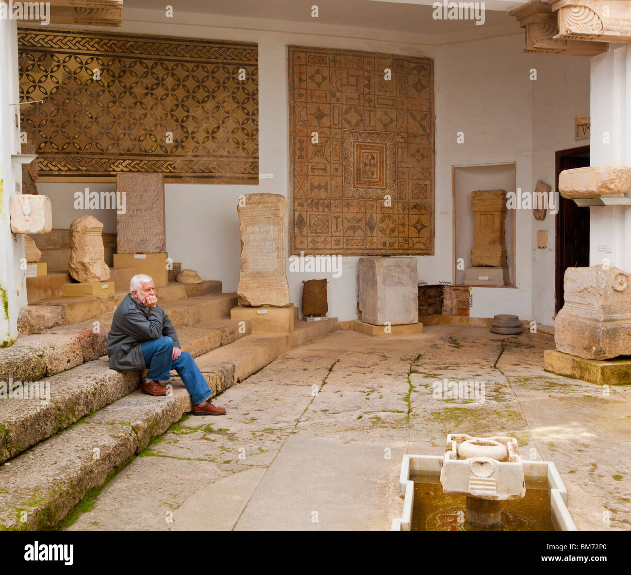Visitor contemplating Roman antiquities in Museo arqueologico y etnologic, Cordoba, Cordoba Province, Spain. Stock Photo