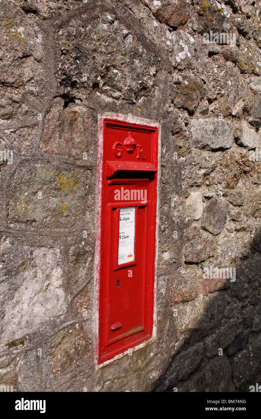 Red letter box in stone wall. Stock Photo
