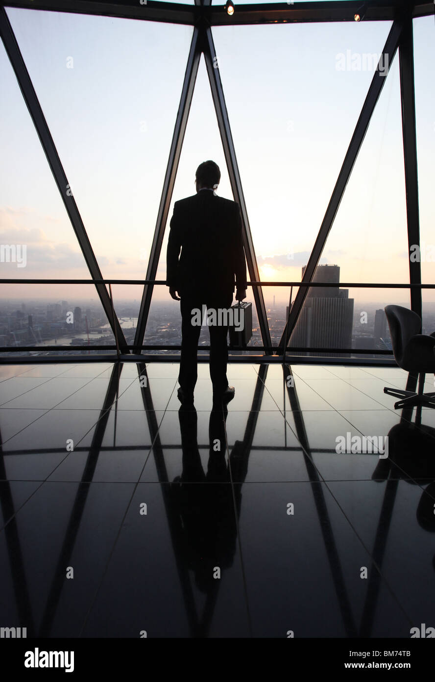 A businessman stand with his briefcase at the top of the Gherkin skyscraper in the city of London, U.K. Stock Photo