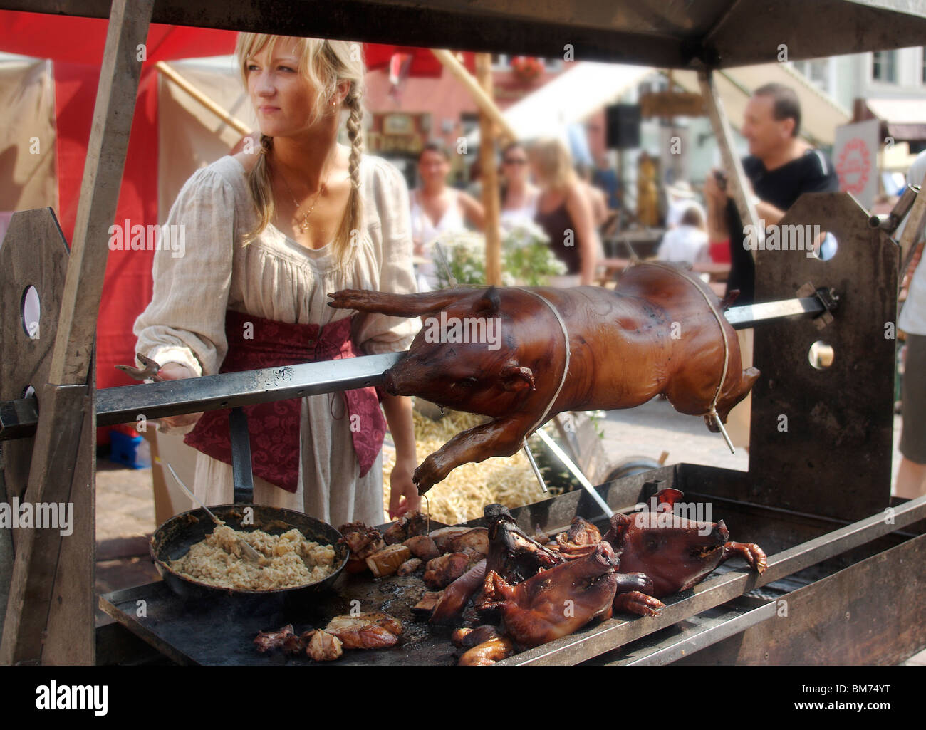 A girl cooks a pig during a medieval market in Tallinn, Estonia Stock Photo