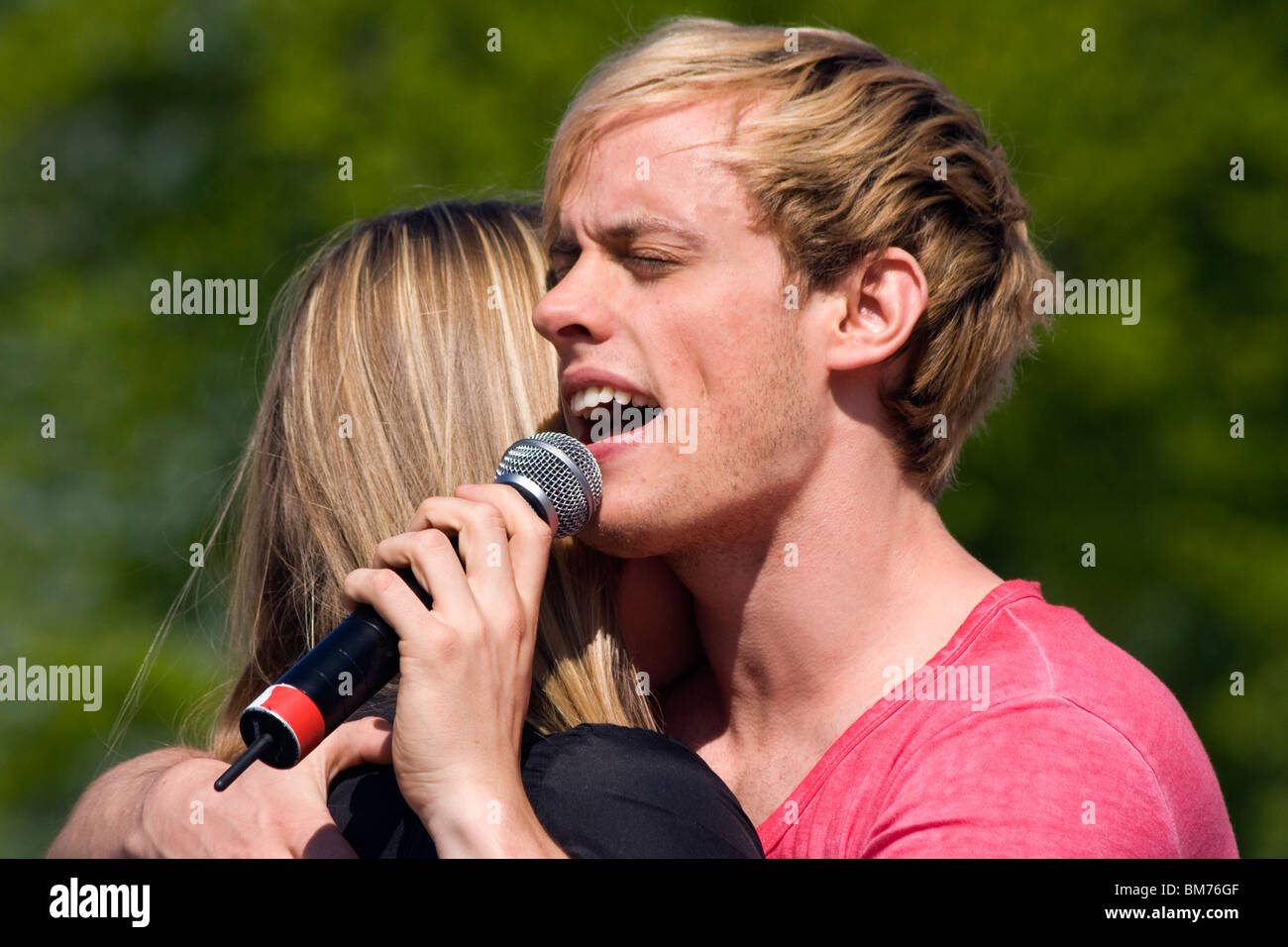 Pär Stenhammar in the Lovestoned pop group singing while hugging a fan. Stock Photo