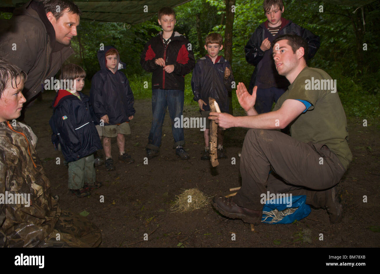 Children being taught bushcraft skills by instructor on course in woodland on Gower Swansea South Wales UK Stock Photo