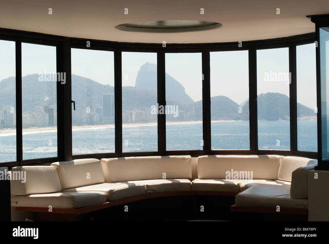 Oscar Niemeyer architect draws his designs on the wall and on paper of his Copacabana studio in Rio de Janeiro, Brazil. Oscar Ribeiro de Almeida Niemeyer Soares Filho (December 15, 1907 December 5, 2012). View of Sugar Loaf Mountain from Niemeyer's studio. Sugar loaf mountain and its simple shape was  huge inspiration to Niemeyer's architecture. Stock Photo