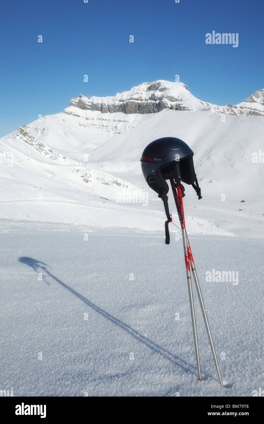 Ski poles and helmet with the back bowls of Lake Louise in the background Banff National Park