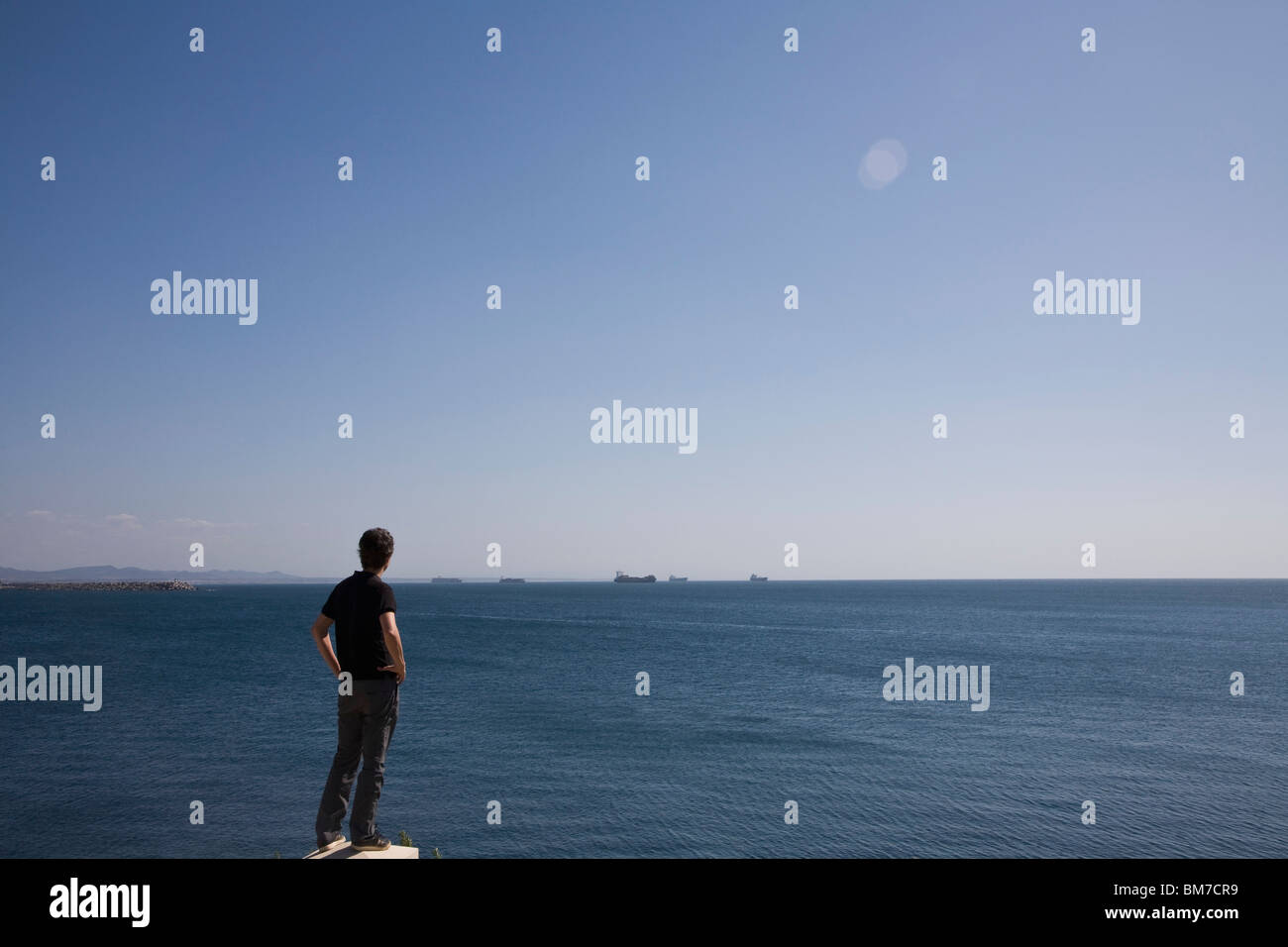 Rear view of a man looking out to sea, Sines, Portugal Stock Photo - Alamy