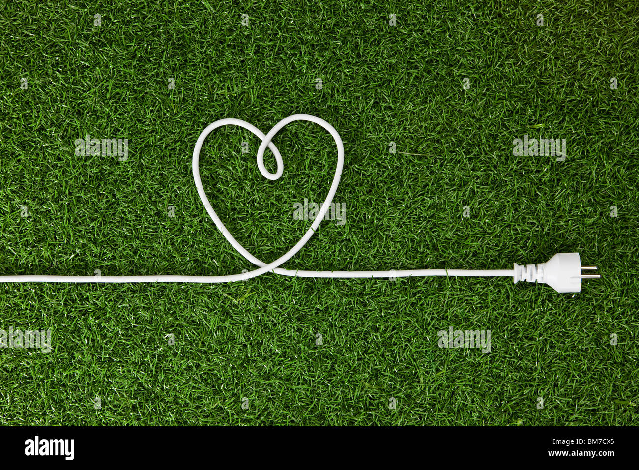 An electrical cord arranged in a heart shape on grass Stock Photo Alamy