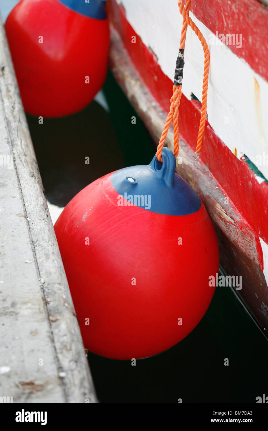 Boat bumpers tied to a boat docked at a jetty Stock Photo