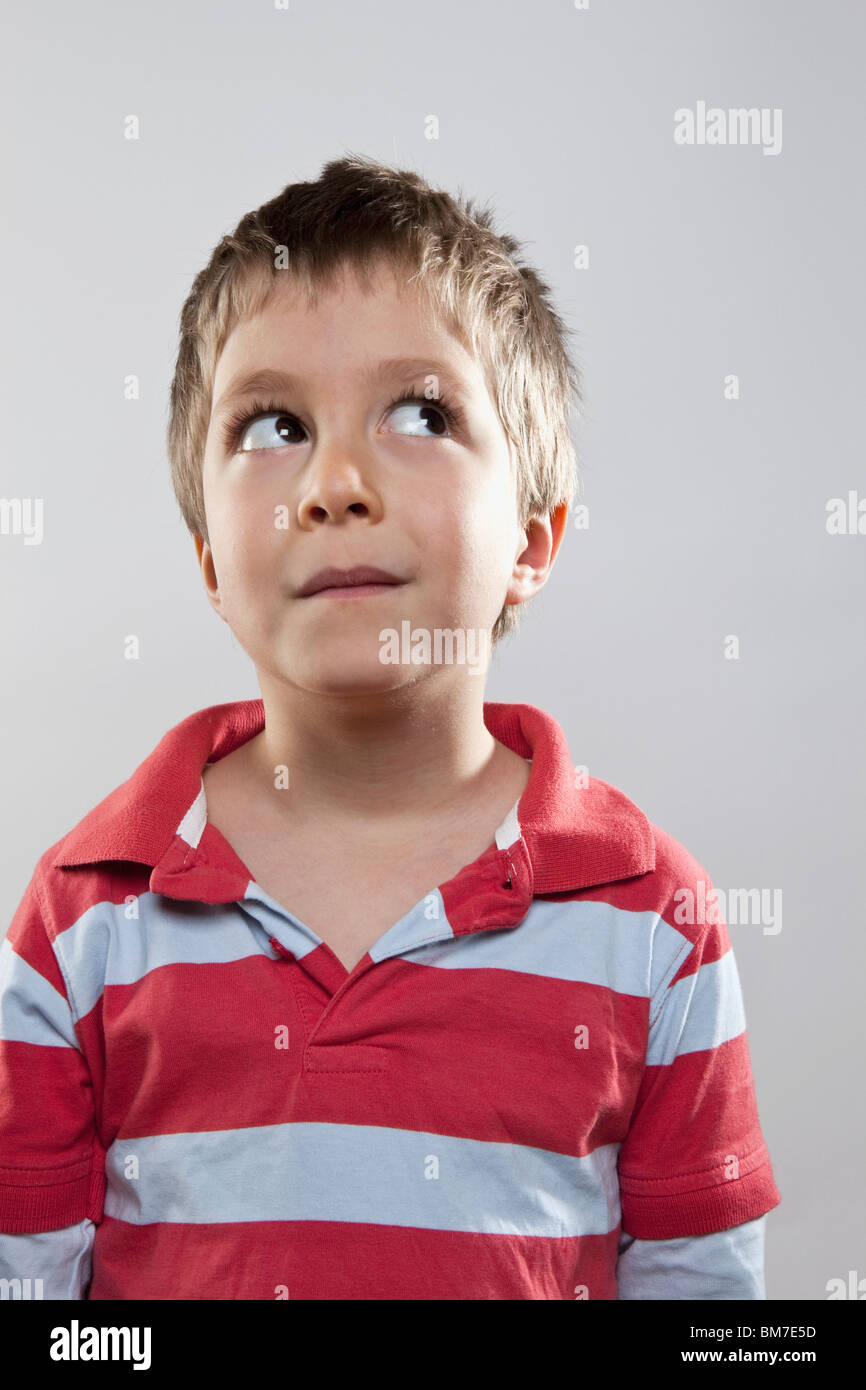 A young boy looking up and to the side, studio shot Stock Photo