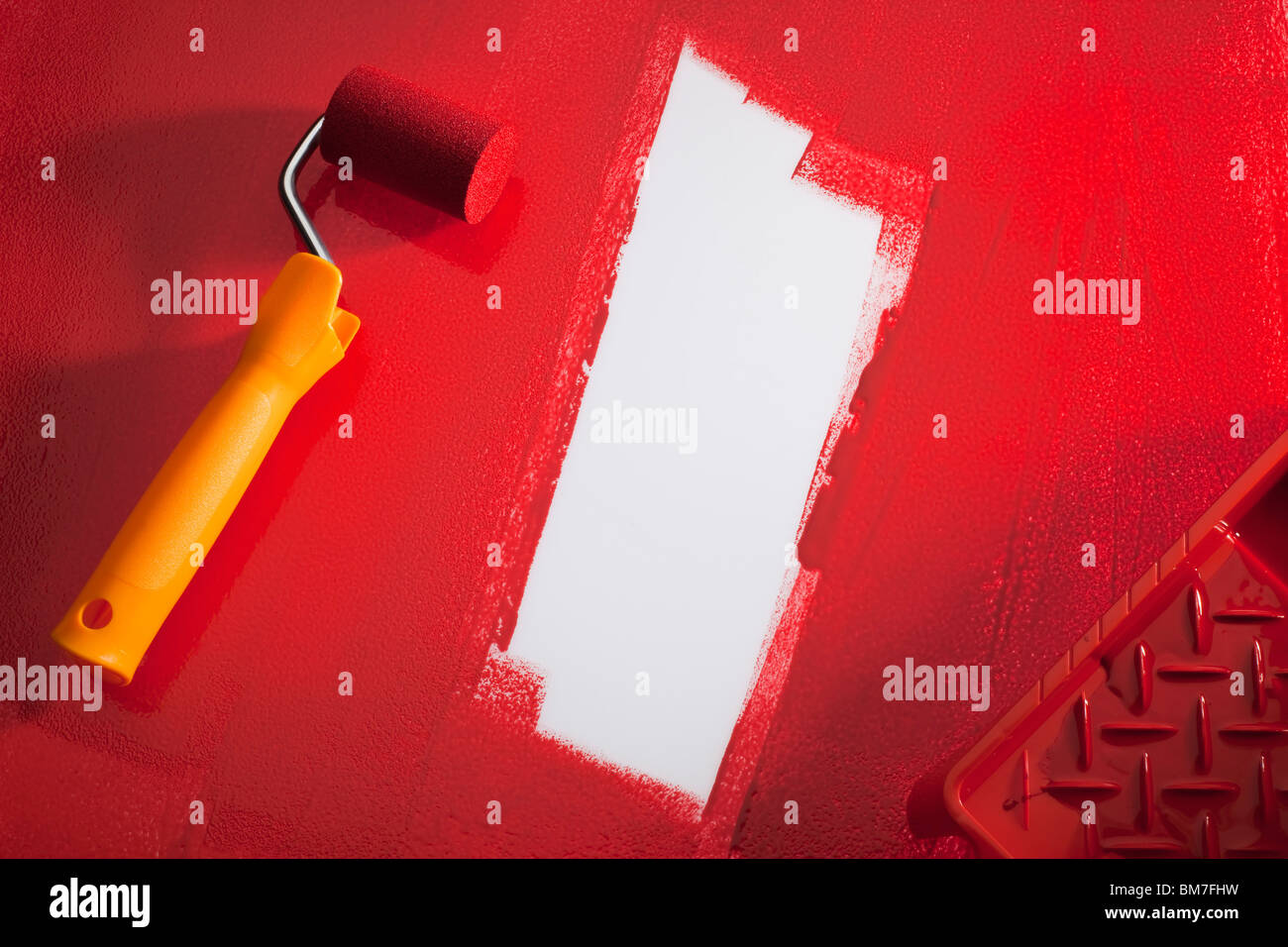 A Paint Roller With Red Paint Stock Photo