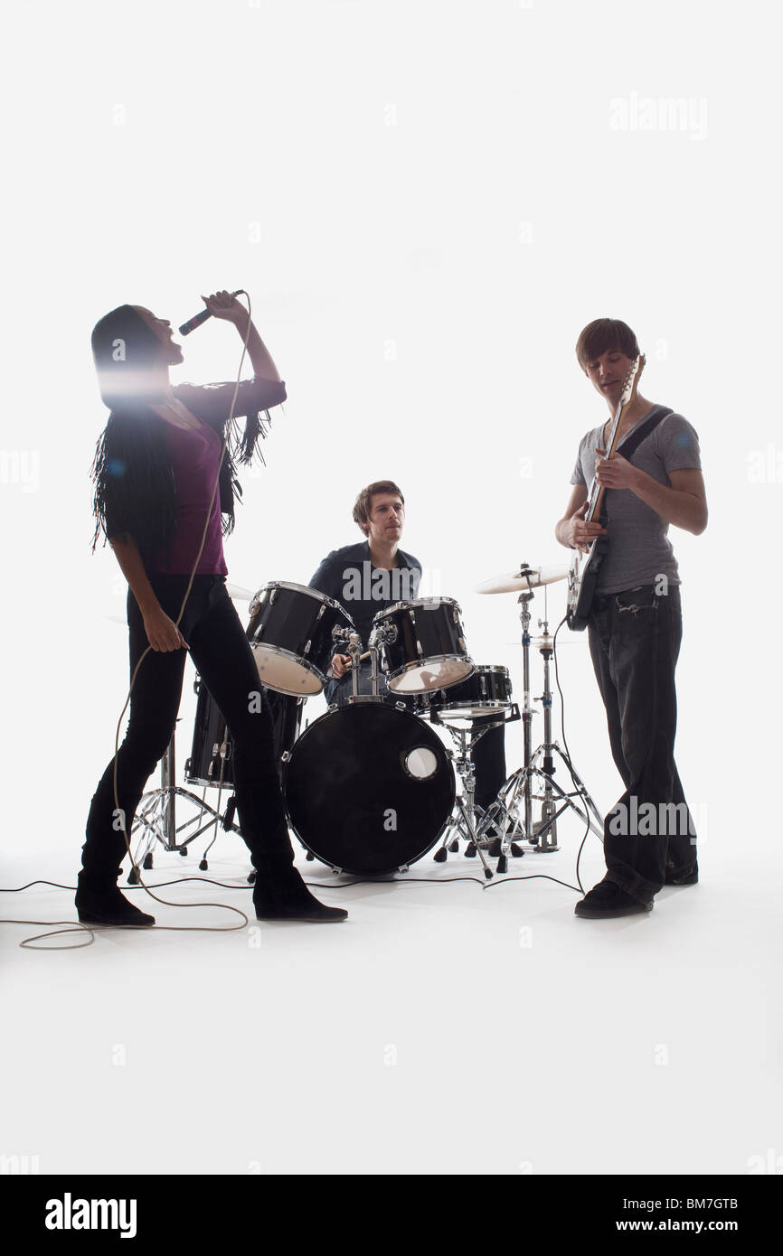 A drummer, guitarist and singer performing, studio shot, white background,  back lit Stock Photo - Alamy