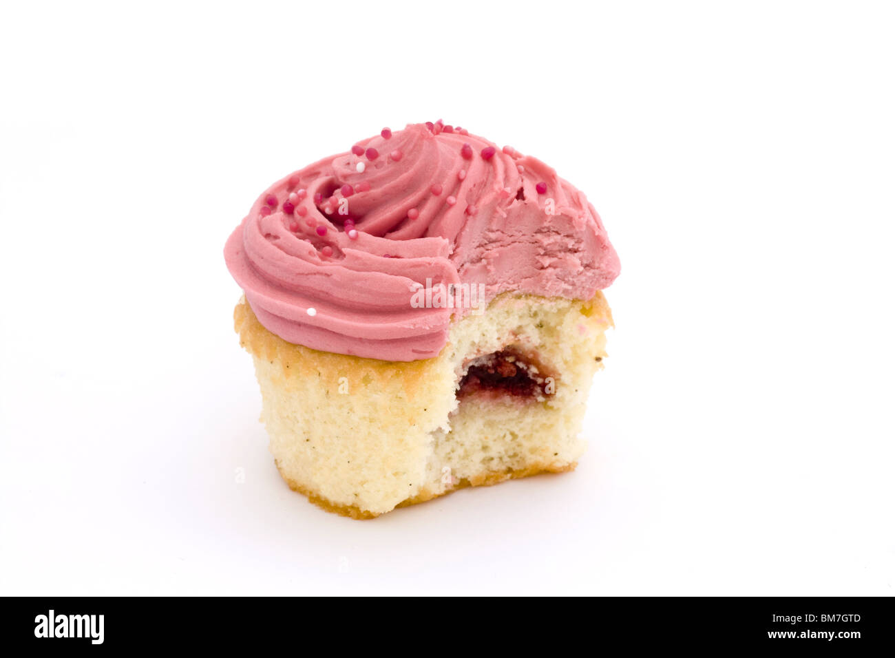 pink cupcake with bite taken over white Stock Photo