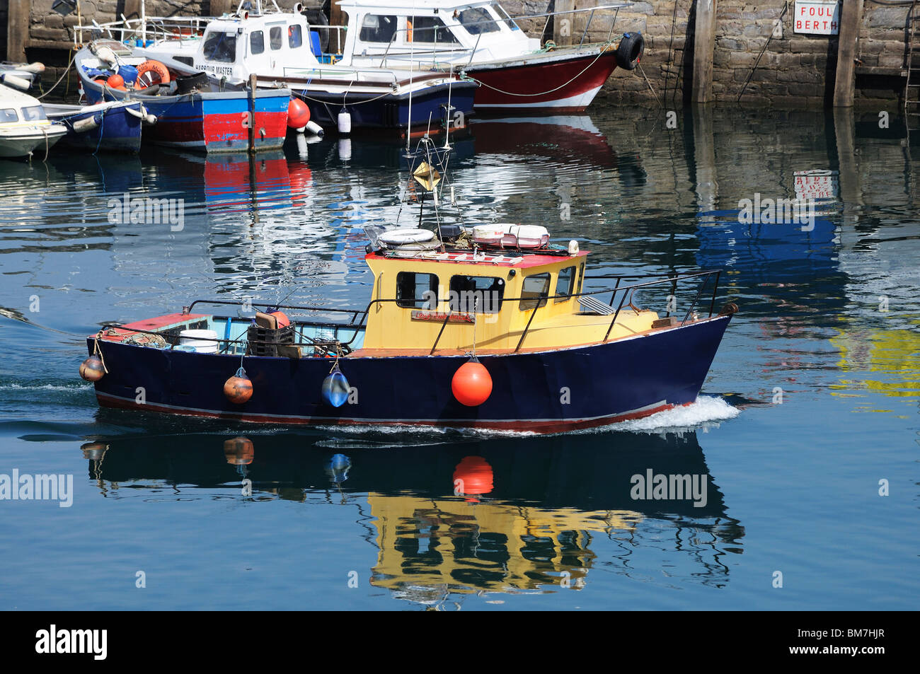 a fishing boat leaving the harbour at brixham in devon, uk Stock Photo