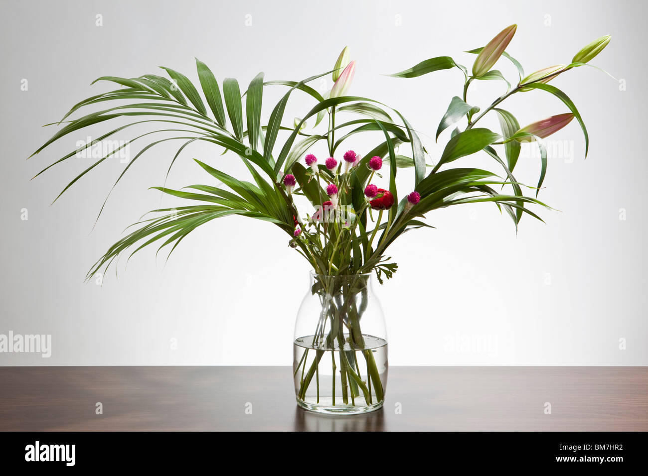A bunch of Easter lilies and Gomphrena flowers in a vase Stock Photo