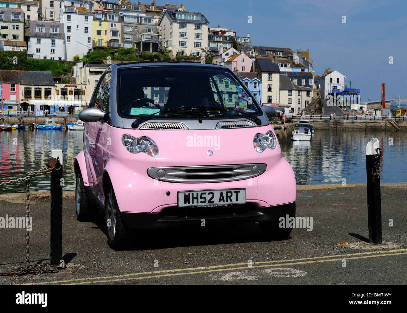 a pink smart car parked harbourside in brixham, devon, uk Stock Photo