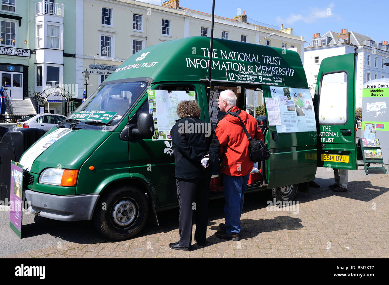a man and woman looking at joining information on a national trust sales van in falmouth, cornwall, uk Stock Photo
