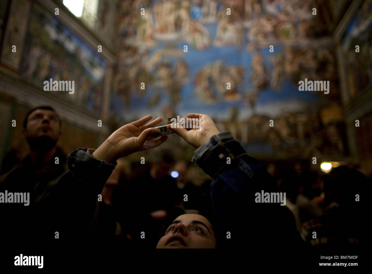 A tourist photographs the ceiling of the Sistine Chapel by Michelangelo in the Vatican Museum, Rome, Italy. Stock Photo