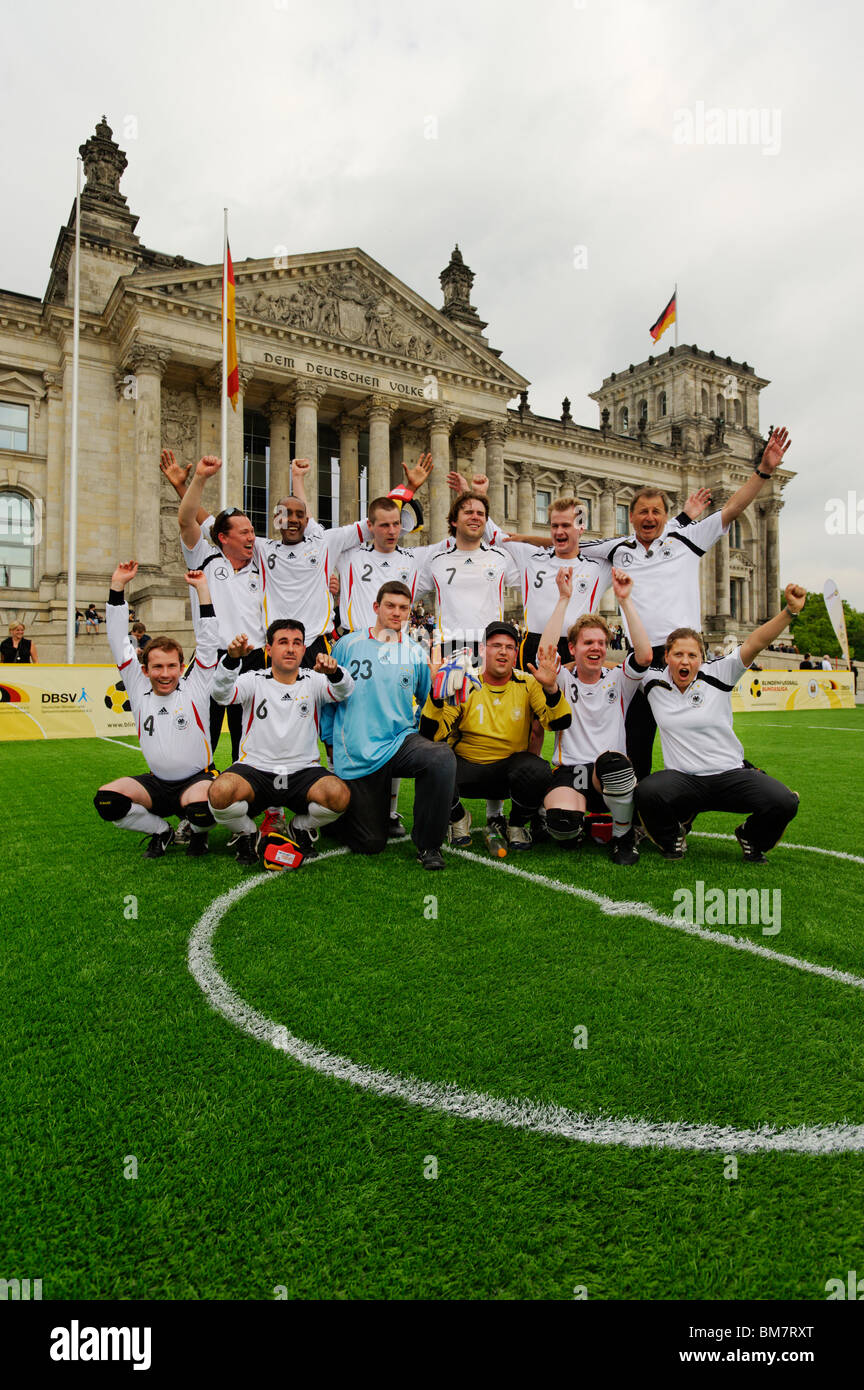 A cheering German blind football international team  in front of the Reichstag building, Berlin, Germany, Europe Stock Photo