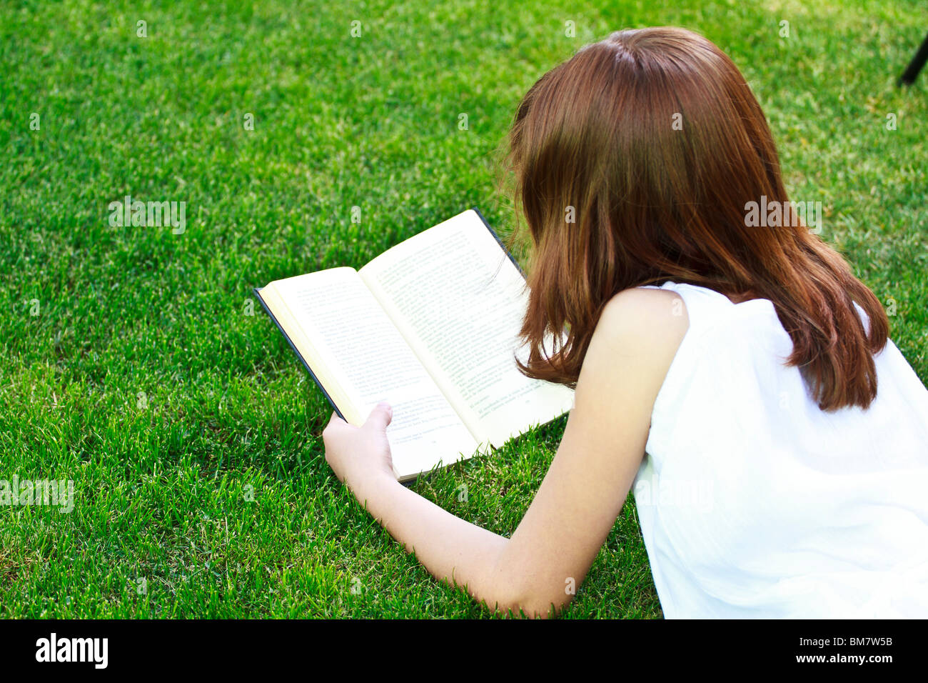 Young beautiful girl reading a book outdoor Stock Photo - Alamy