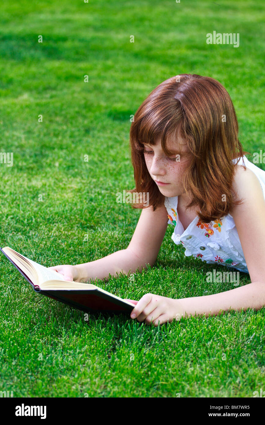 Young beautiful girl reading a book outdoor Stock Photo - Alamy