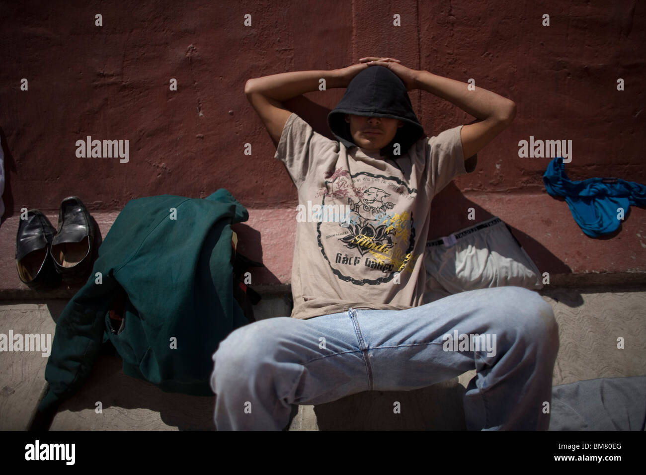 An undocumented Central American migrant traveling across Mexico to work in the US sleeps in a shelter in Mexico City, Mexico. Stock Photo