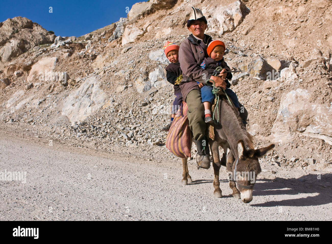 Donkey Grad Gradfather with gradchildren riding a donkey, between Sary Tash and Osh ...
