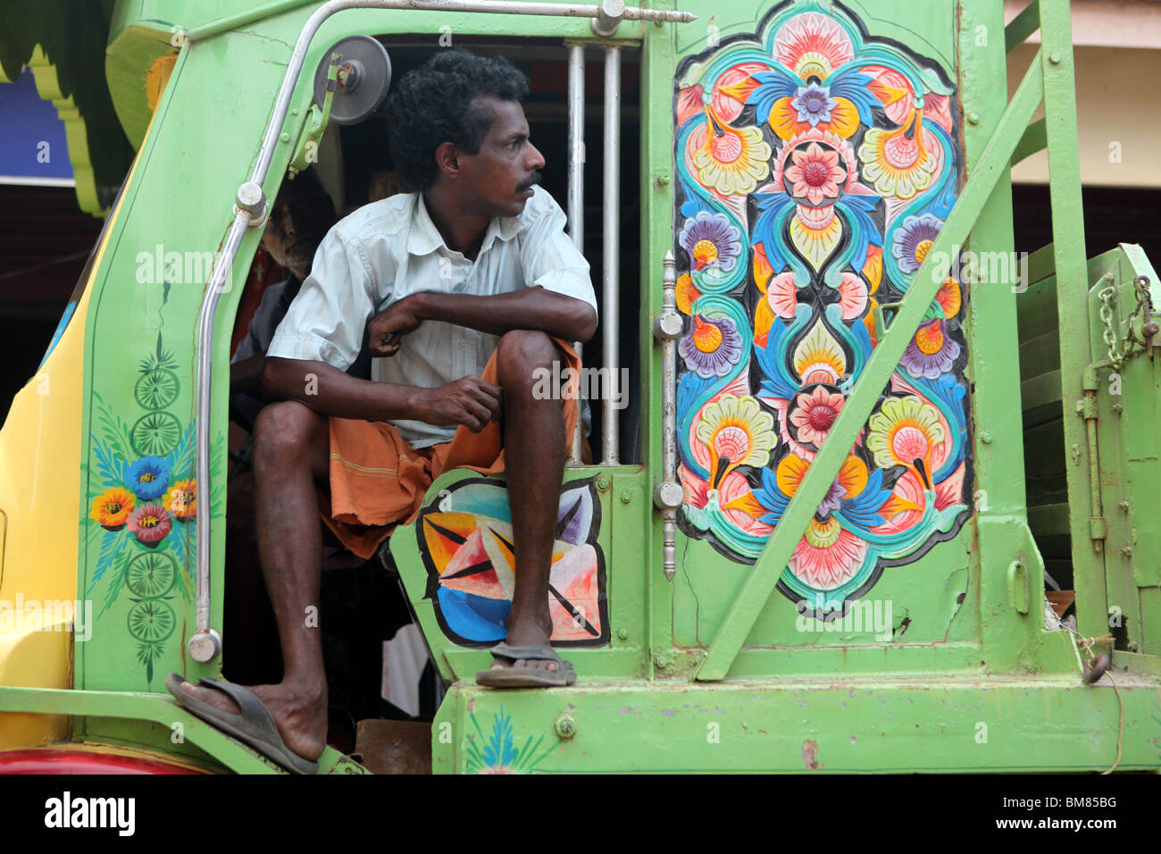 A man sitting a decorated truck in Kochi, formerly known as Cochin in Kerala, India. Stock Photo