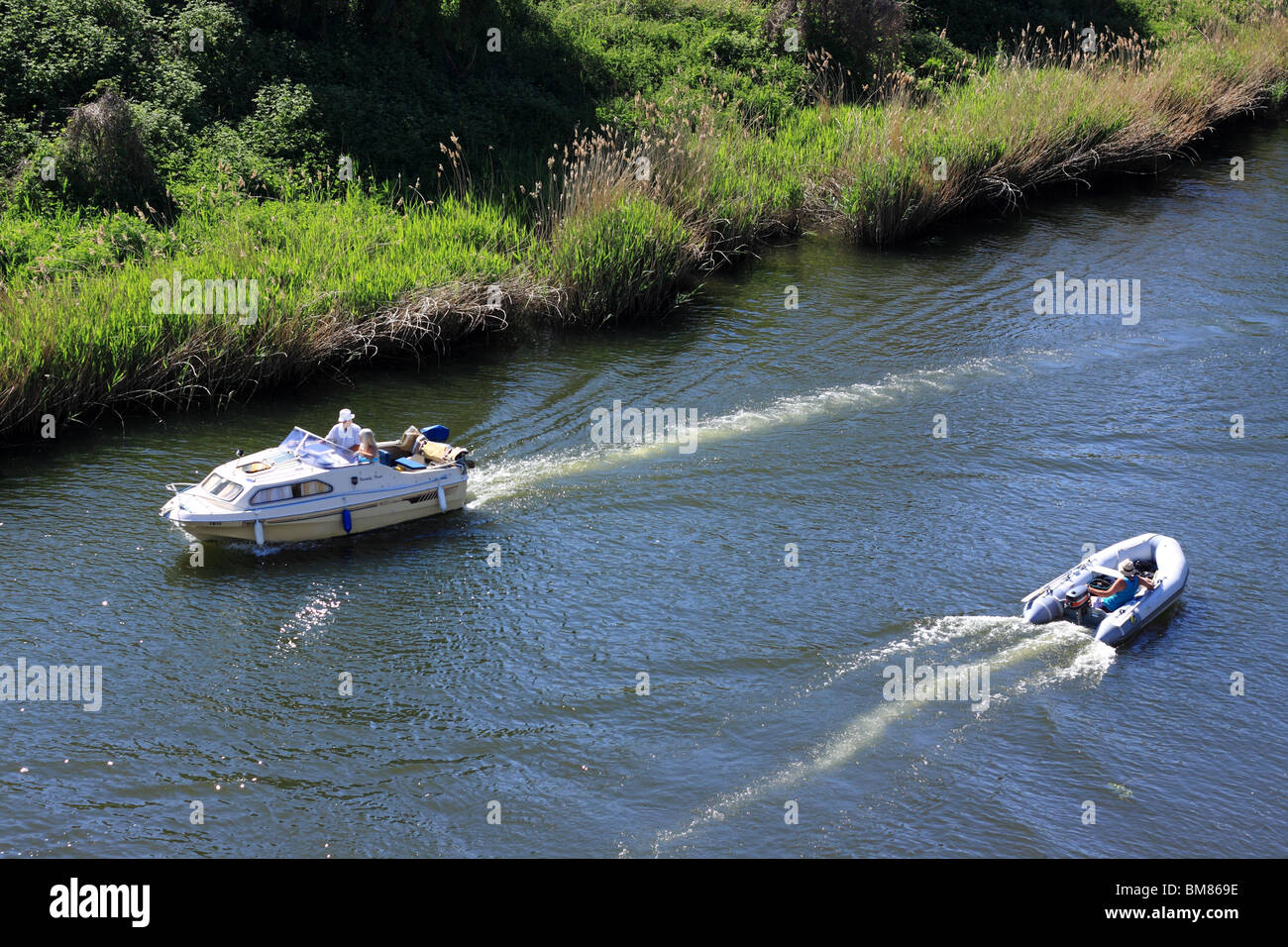 cabin cruiser and inflatable dinghy on River Stour Stock Photo