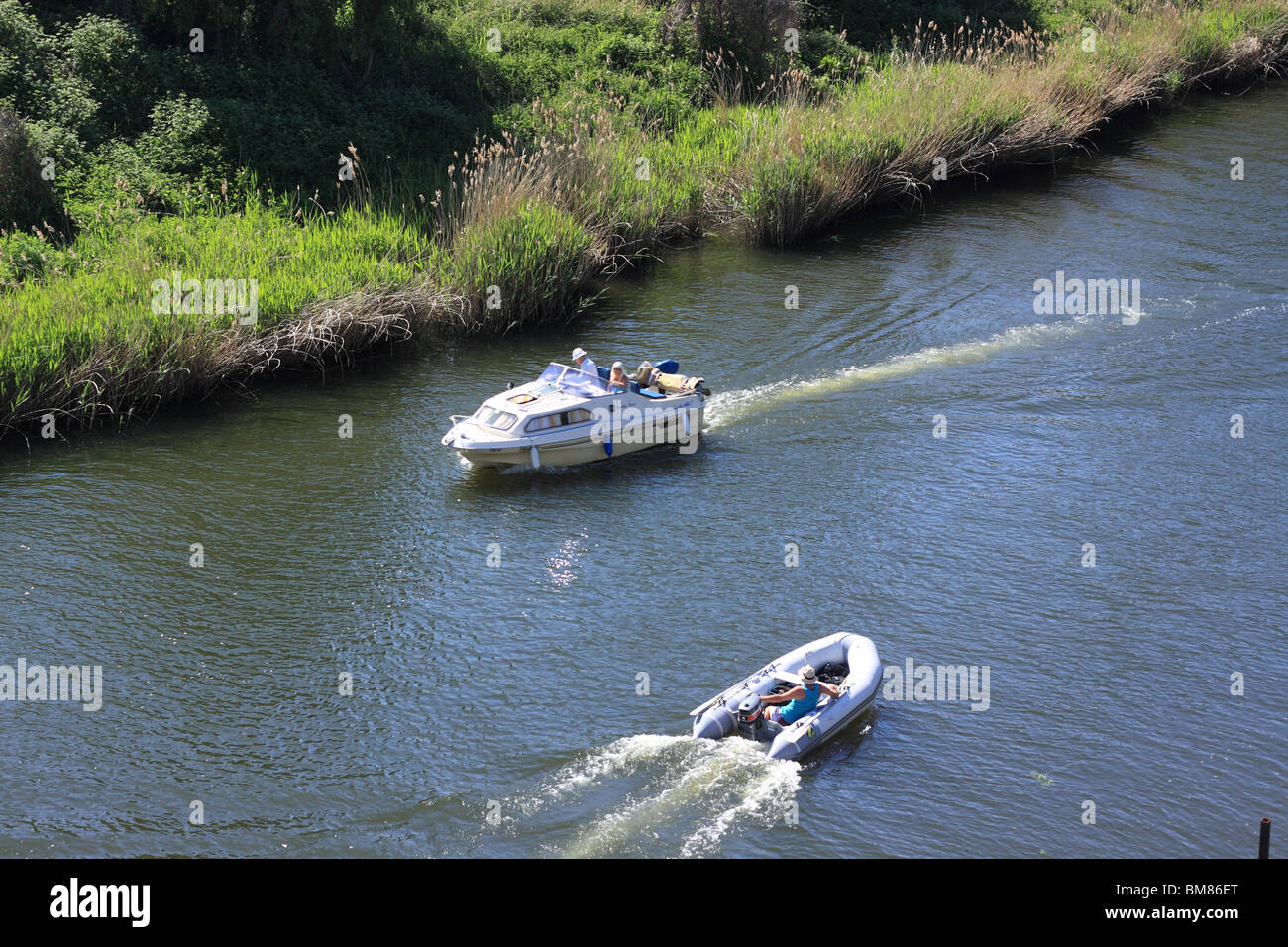 cabin cruiser and inflatable dinghy on River Stour Stock Photo