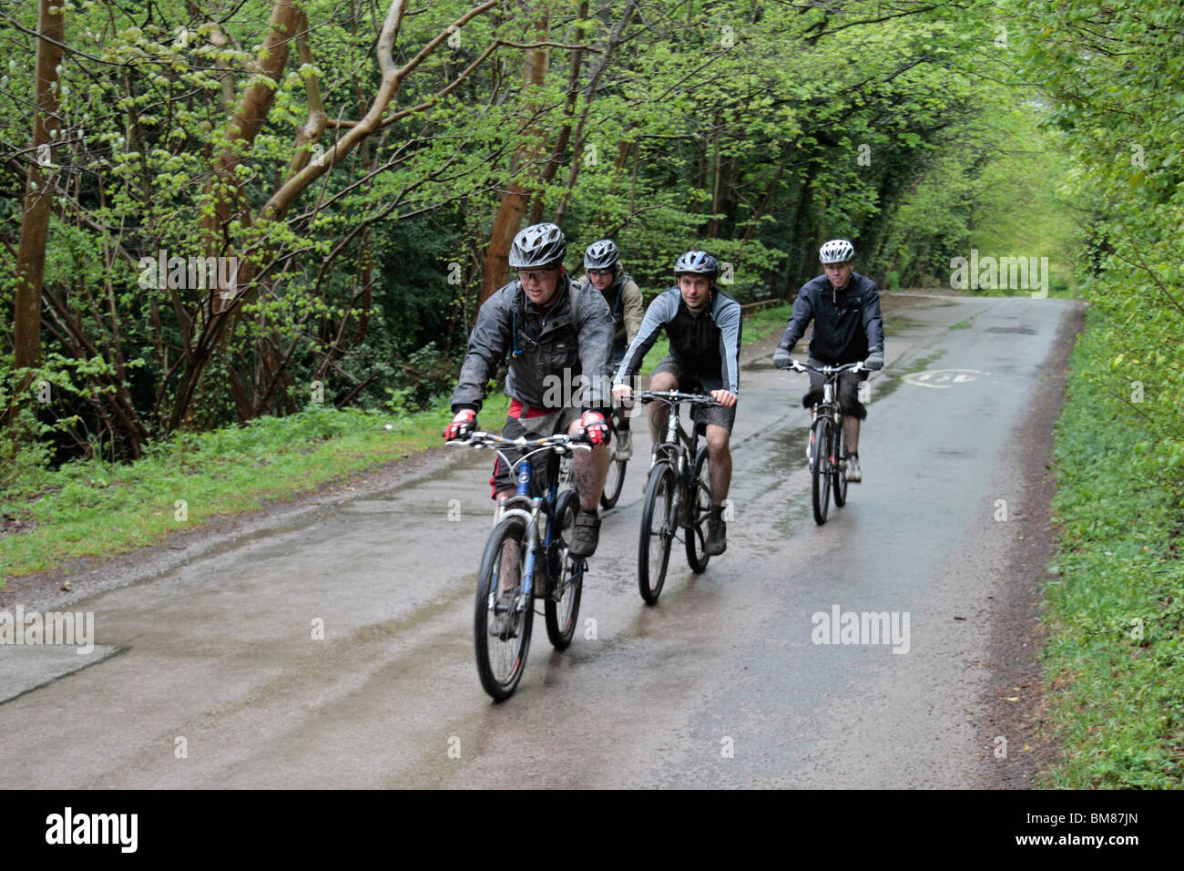 Four mountain bikers on a wet road near Wendover, Chiltern Hills