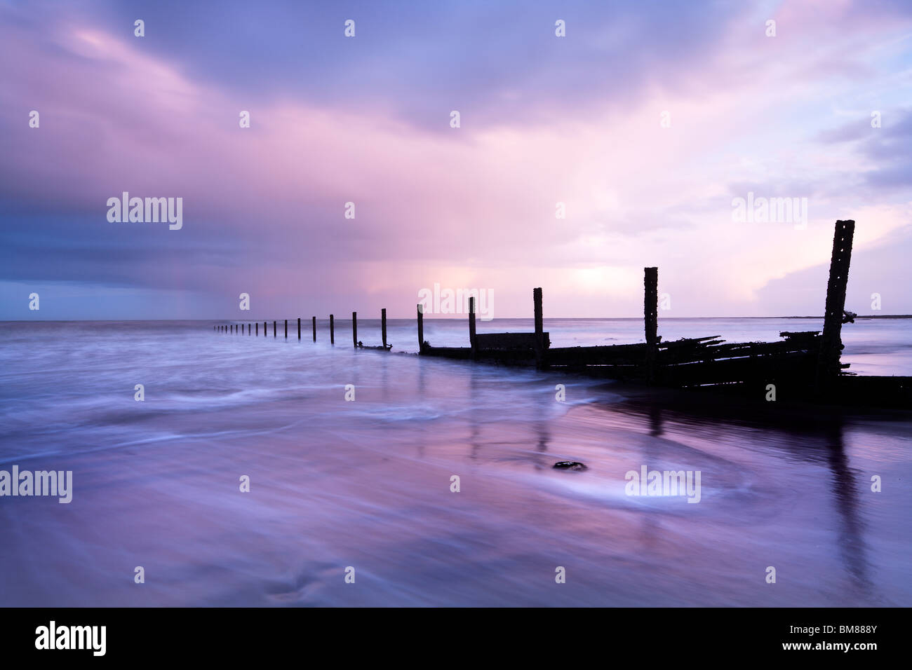 a squally shower passes through at sunset at The Warren, Folkestone, Kent Stock Photo