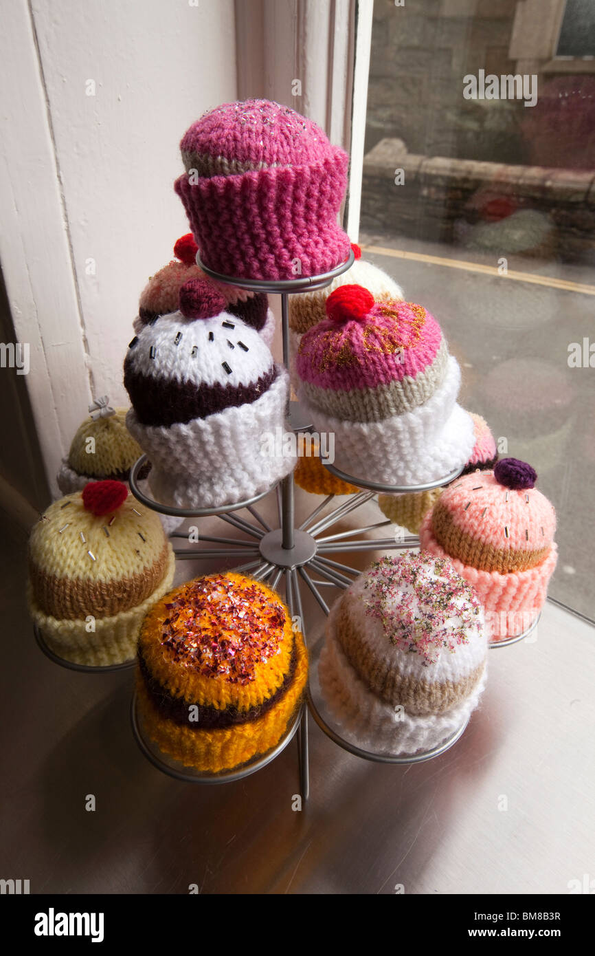UK, England, Cornwall, Launceston, Castle Street, plate of colourful knitted fairy cakes in tea shop window Stock Photo