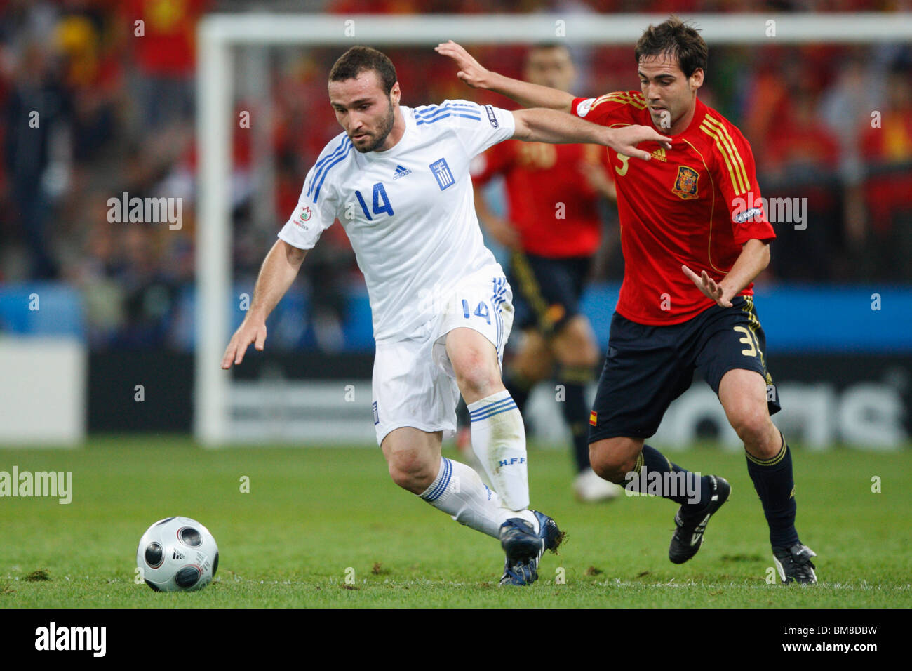 Dimitris Salpingidis of Greece (14) and Fernando Navarro of Spain (3) contest the ball during a UEFA Euro 2008 football match. Stock Photo