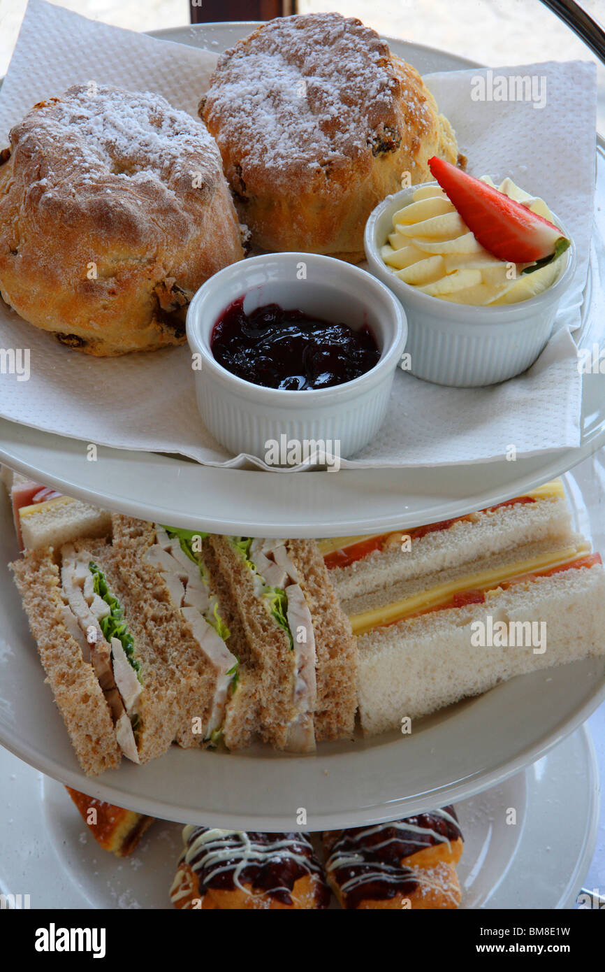 Finger cut sandwiches, Scones and Eclairs provide a tasty mid afternoon tea for two Stock Photo