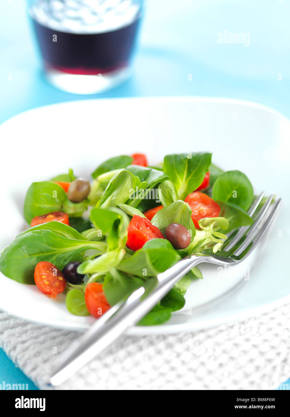 lettuce salad tomato olive vegetarian light food cotton cloth blue  green  red wine Stock Photo