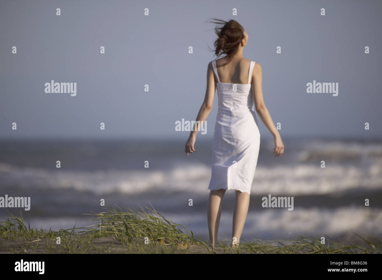 Young woman standing on beach Stock Photo - Alamy